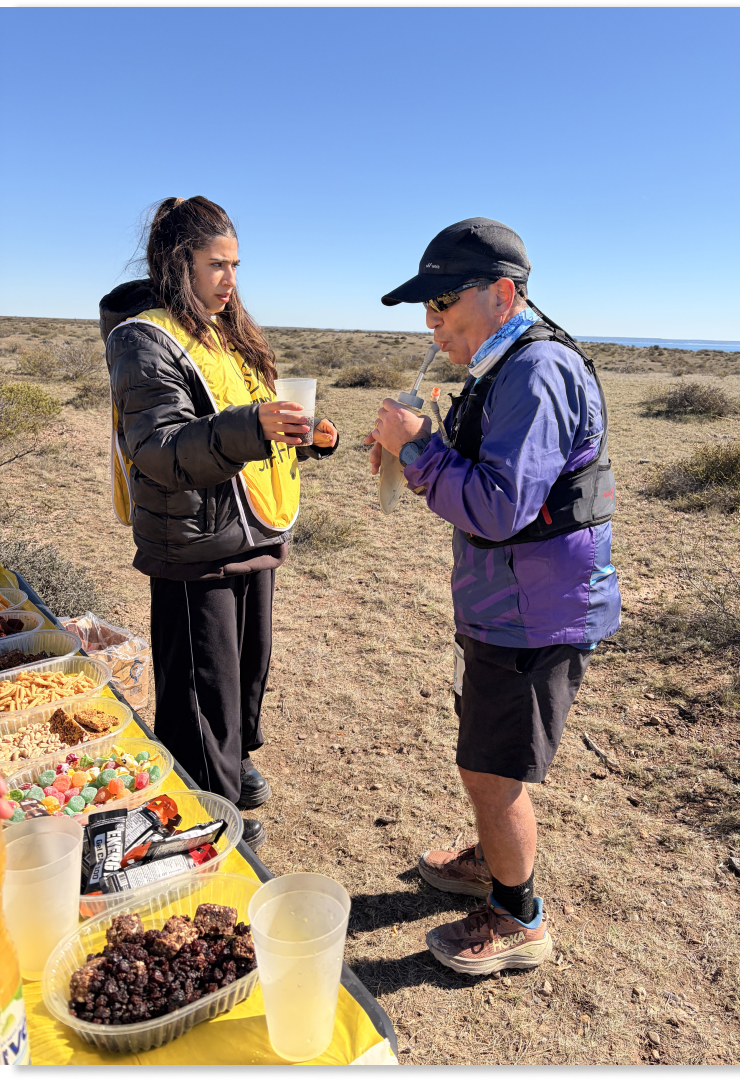 Voluntarios ofreciendo fruta y agua en un puesto de hidratación